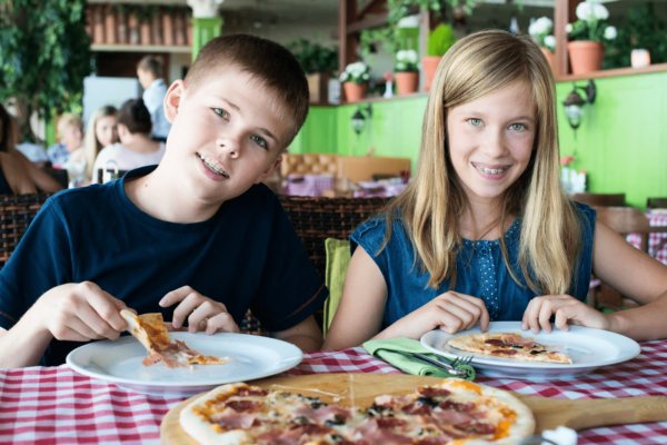 Two children enjoying pizza together.